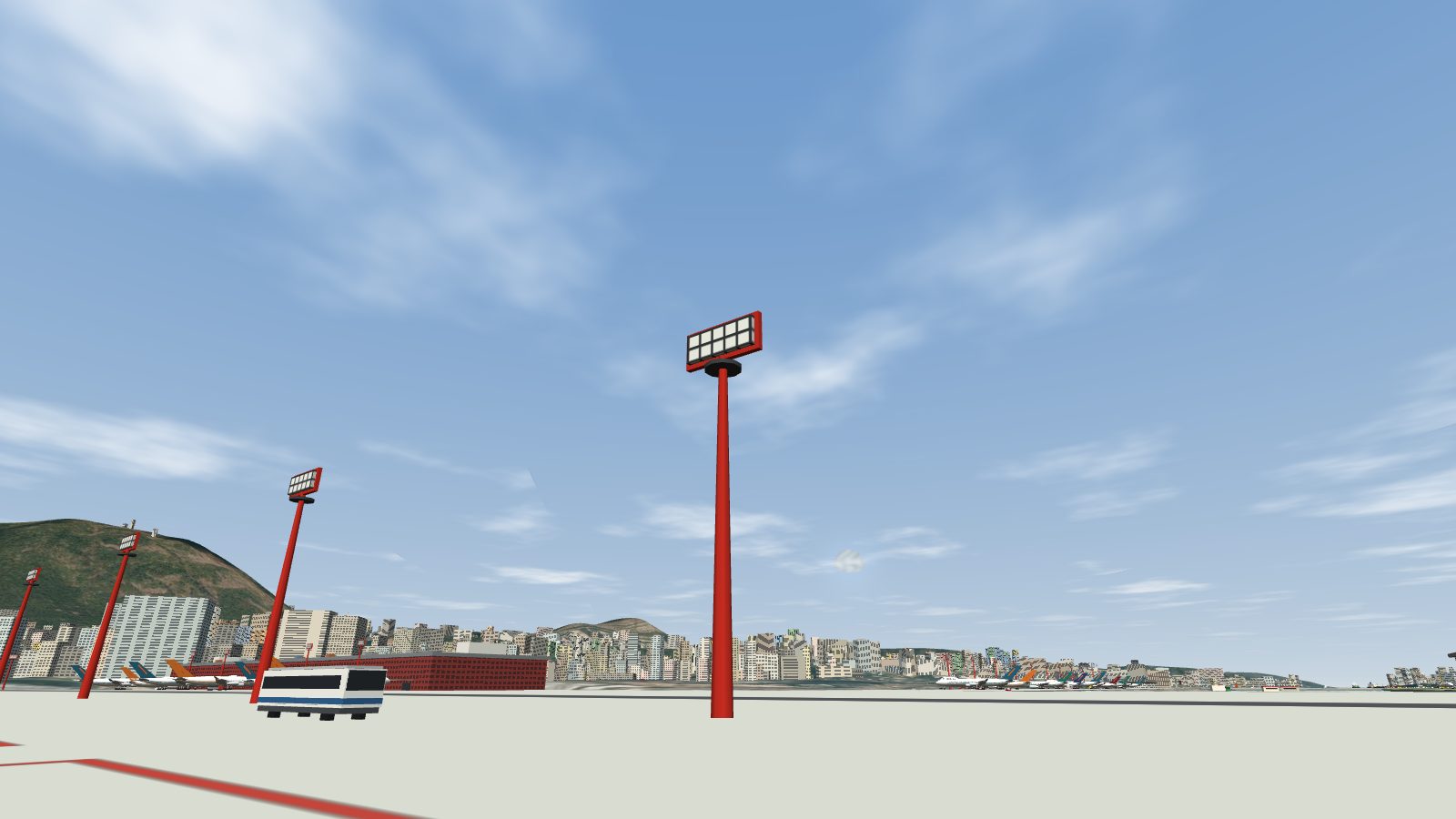 Red floodlight masts by the remote stands on a clear day, their lamps unlit.