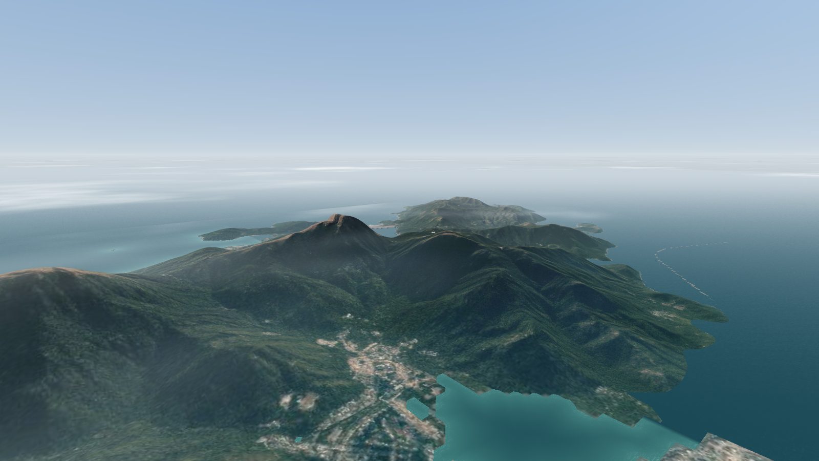 Aerial view along the mountains of Lantau Island, with Lantau Peak in the middle and the sea on both sides.