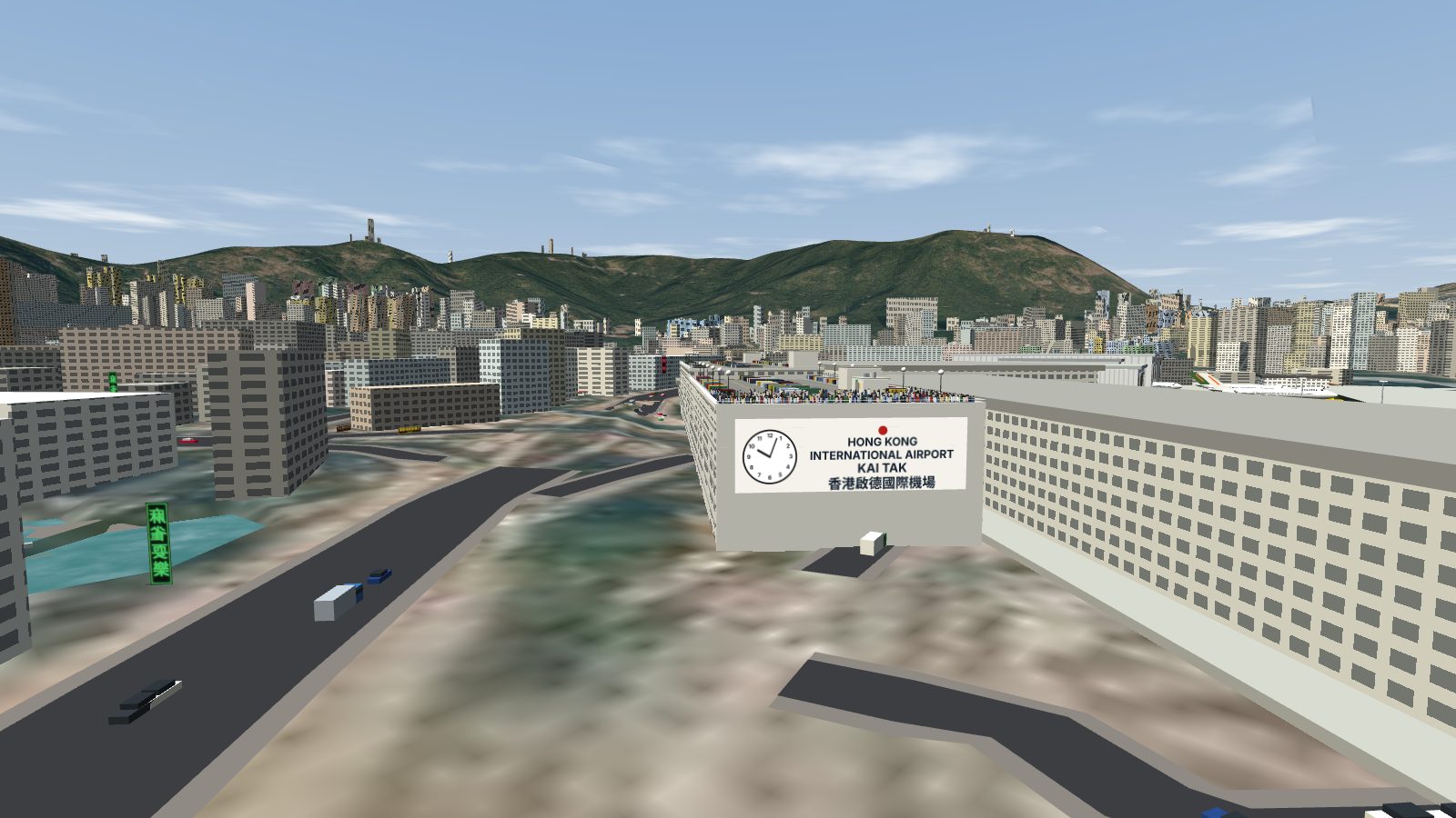 The end wall of the car park with a large clock and the Kai Tak airport sign, spotters lining the roof above it.