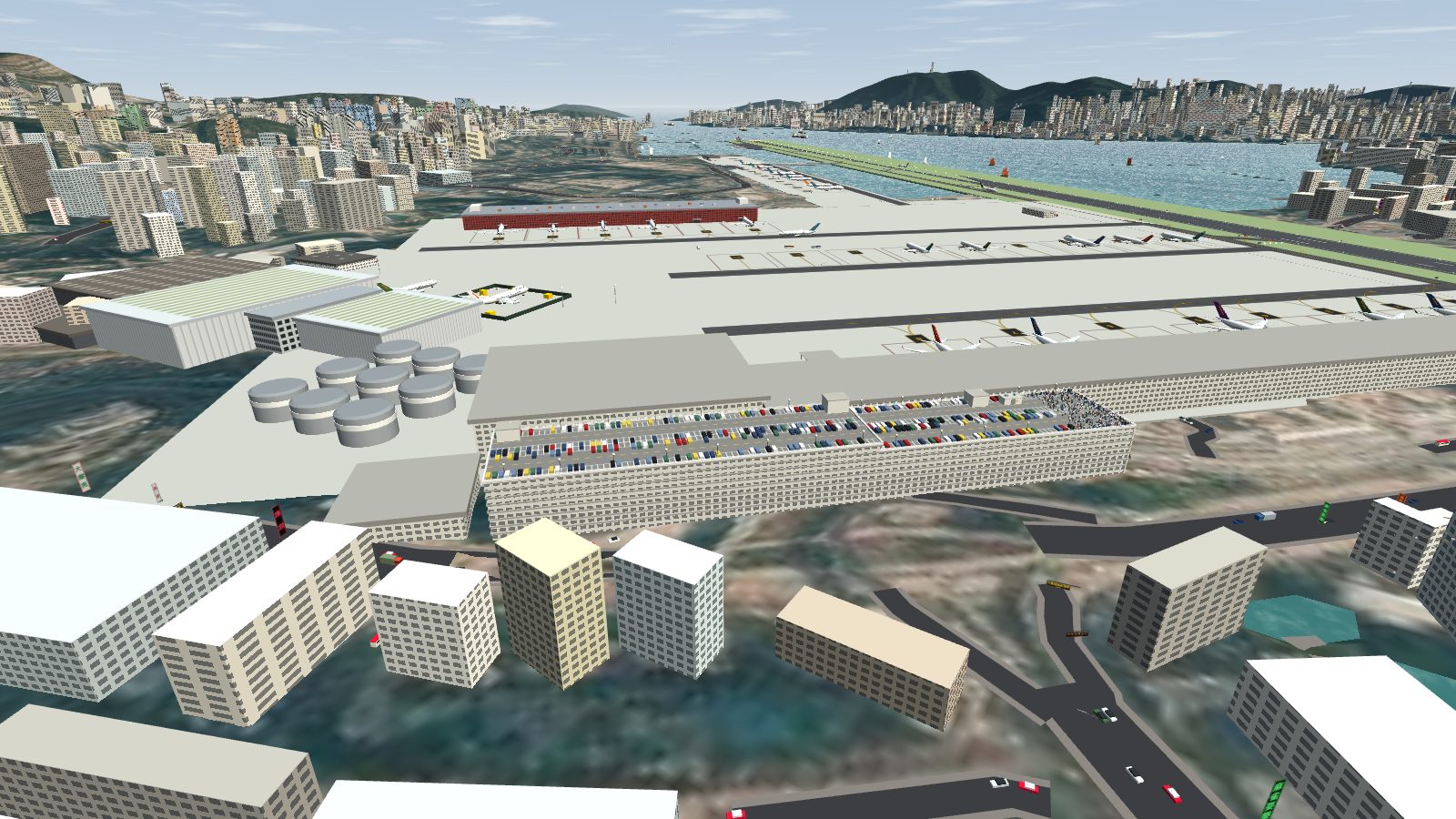 An aerial view of the long car park on the landside of the terminal, its roof full of parked cars and a crowd of spotters at the runway end, with the apron and the runway beyond.