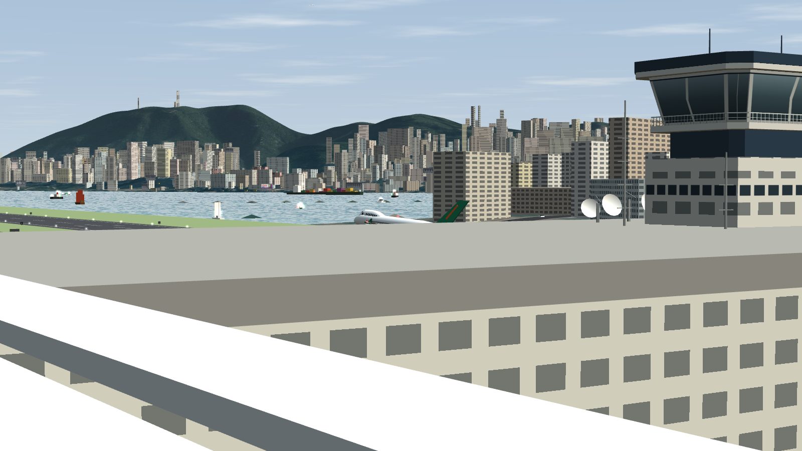 From the car park roof rail: a jet on the runway past the terminal roof, the control tower on the right, Hong Kong Island across the harbour.