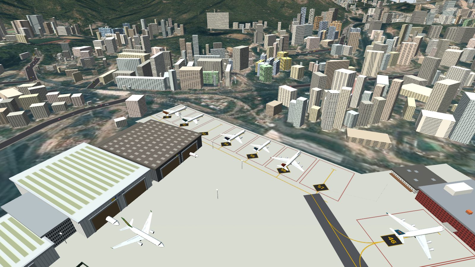 The new east apron past the maintenance hangars, with stands 51 to 57 nose-in toward the boundary road and a taxi lane behind them.