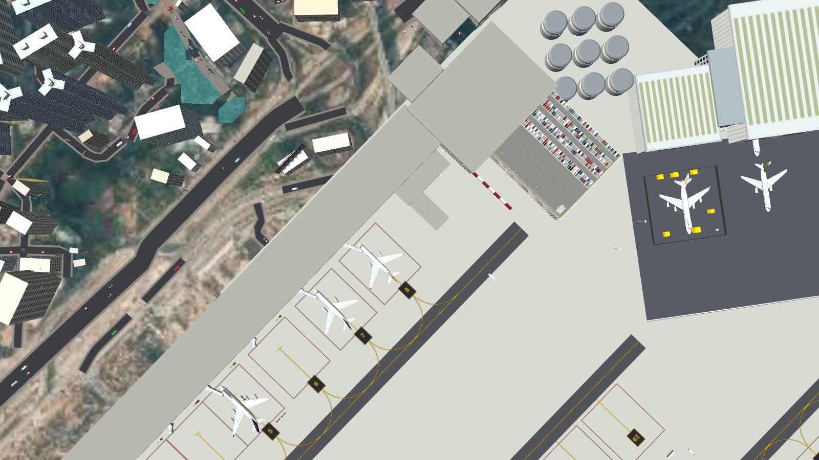 Nine round fuel tanks between the terminal car park and the first hangar, with a dark bitumen apron in front of the hangars.
