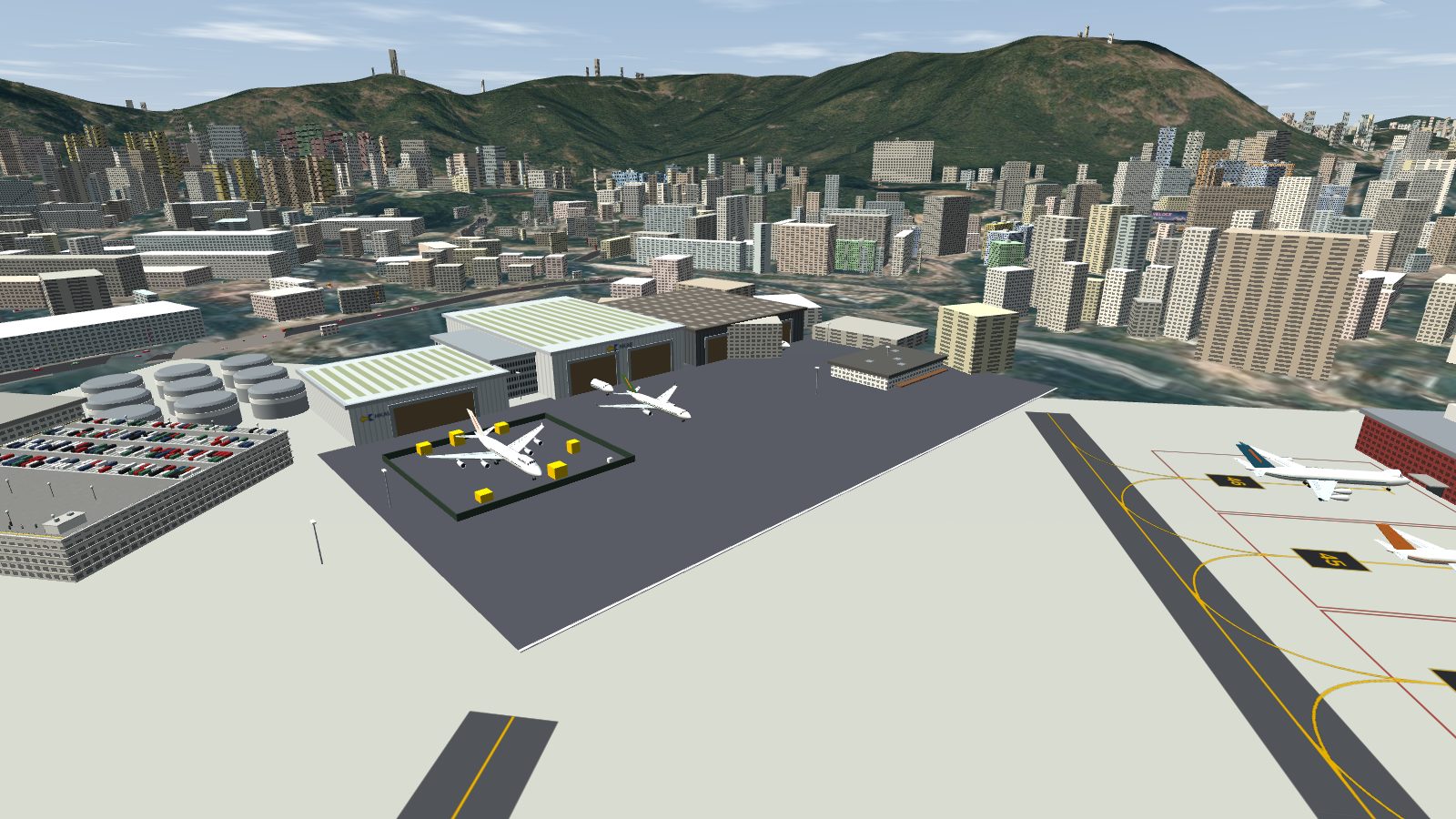 The maintenance area with a dark grey pavement patch in front of the hangars, next to the pale main apron.