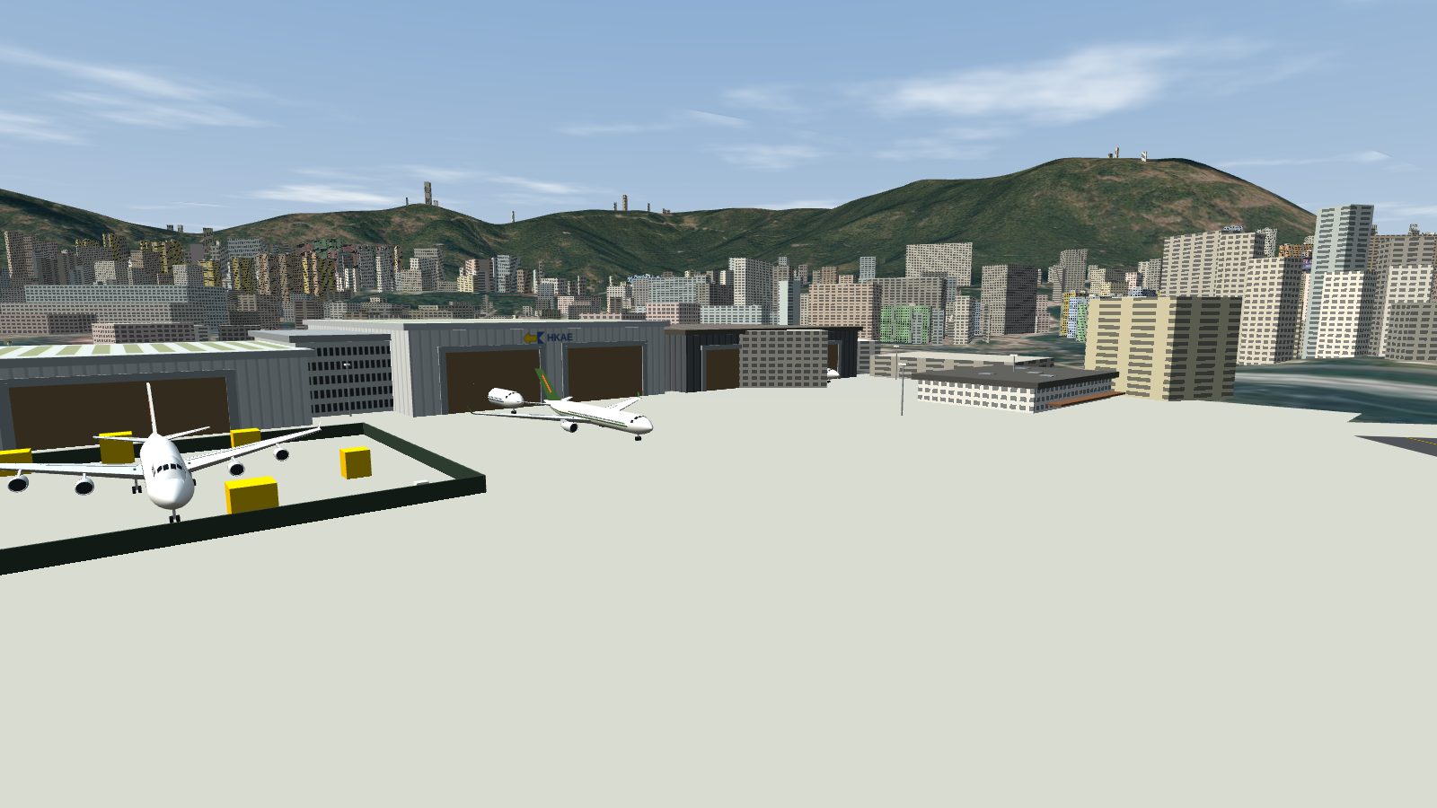 Low view across the concrete maintenance apron towards three hangars with lit bays.