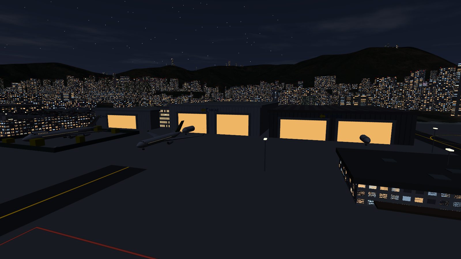 Lit hangar bays and floodlights on the maintenance apron at night, with two aircraft in front.