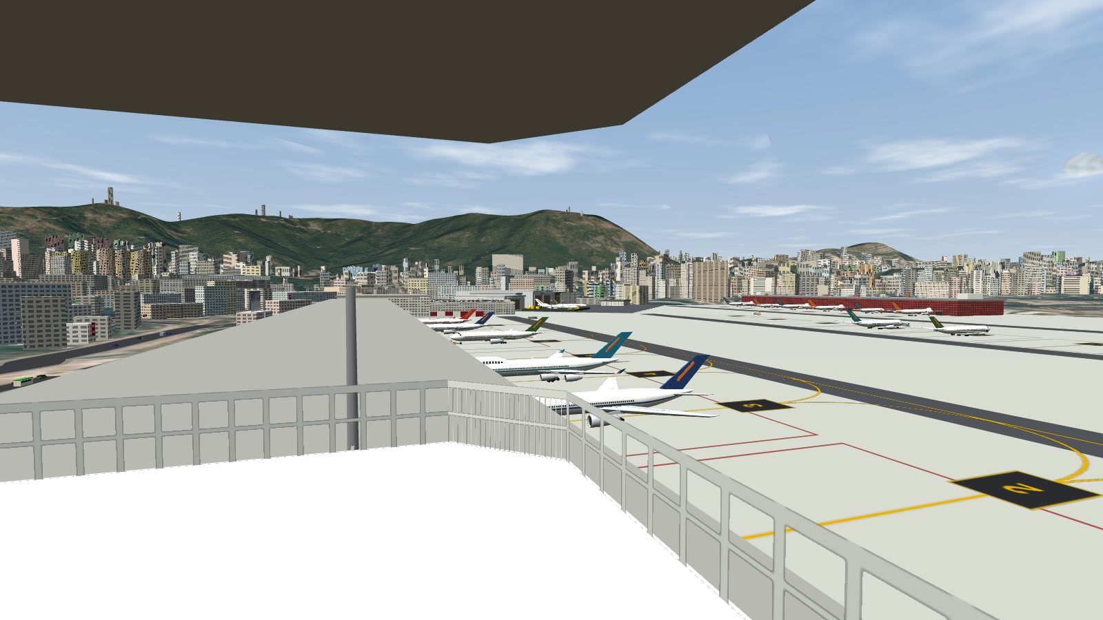 From the tower cab, airliners at the stands along the pier, with Lion Rock behind.